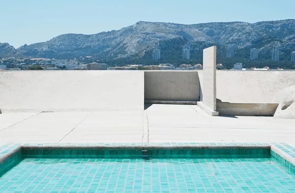 Swimming pool with sun shelf and surrounding hardscape